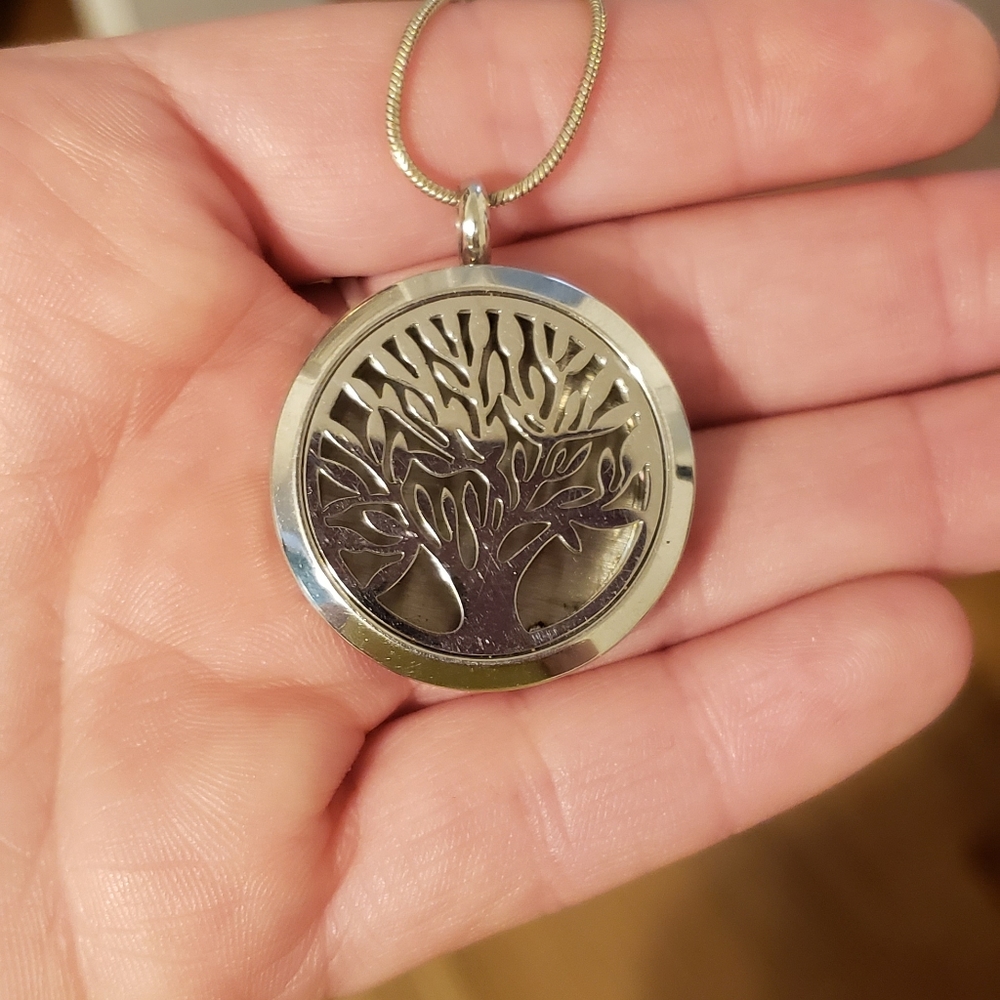 Silver locket with tree cut out of front and chain